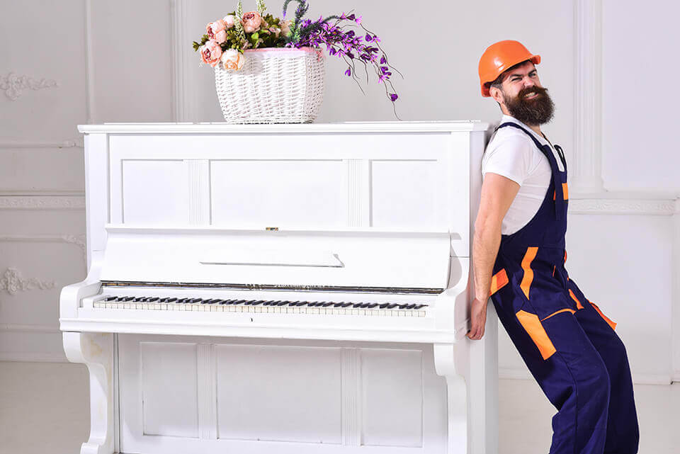 A man carrying a piano