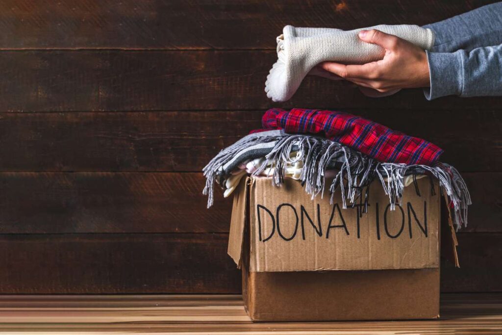 Person placing clothing in the box labeled "donation"