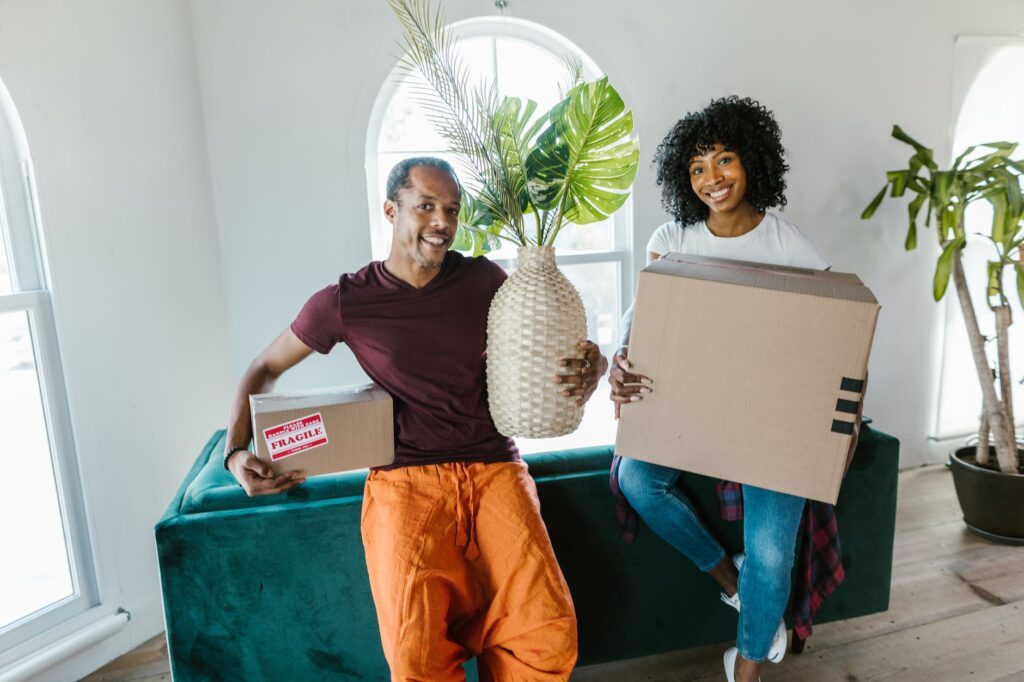 movers holding boxes in a living room
